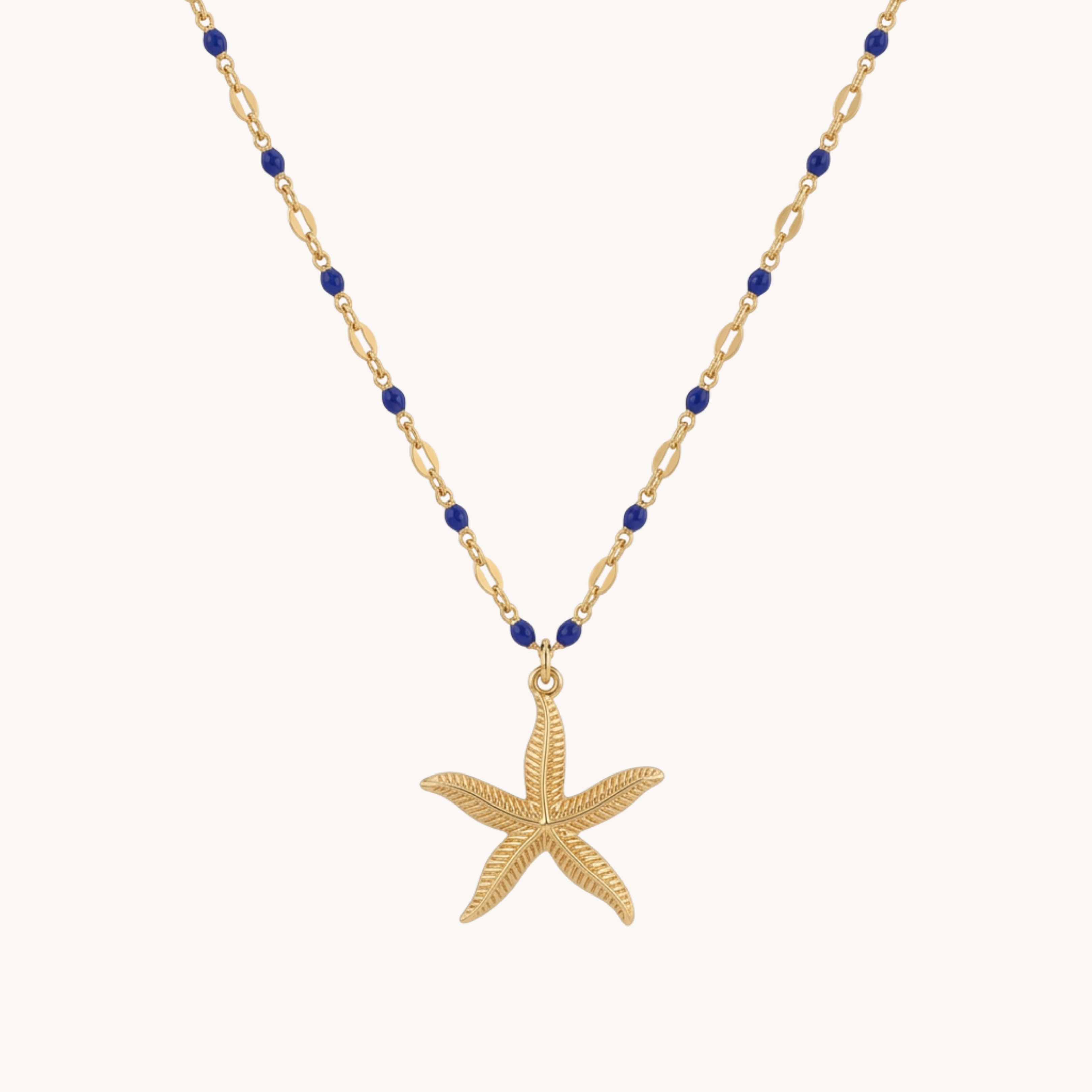 Collana Starfish Sapphire Reef VANDEM in acciaio oro, collana sottile da donna con perline blu cobalto e pendente centrale a stella marina tridimensionale.