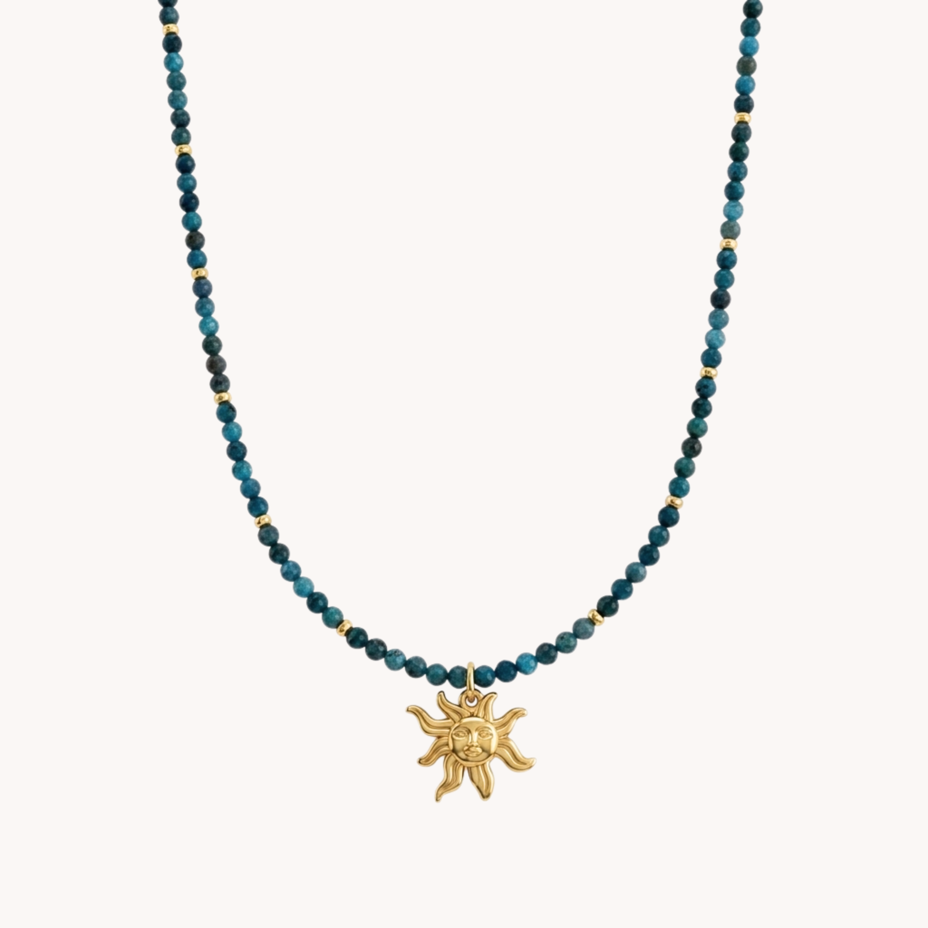 Girocollo Sole Deep Teal VANDEM in acciaio oro, collana da donna con infilata di perline verde petrolio e ciondolo centrale a forma di sole fiammeggiante lucido.