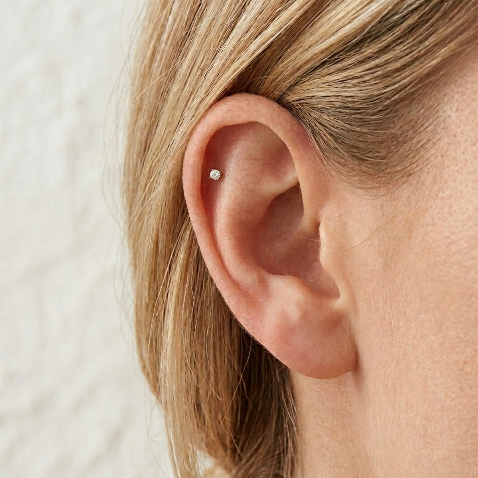 Piercing Punto Luce Solitaire Chic VANDEM in acciaio oro, piercing singolo a perno da donna con castone a griffe e zircone rotondo trasparente lucido.